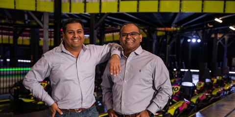 Two men standing in front of go-karts